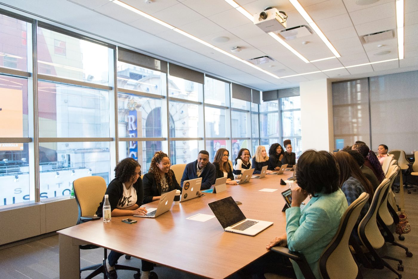 HR team working through reporting exercises on laptops around a conference table