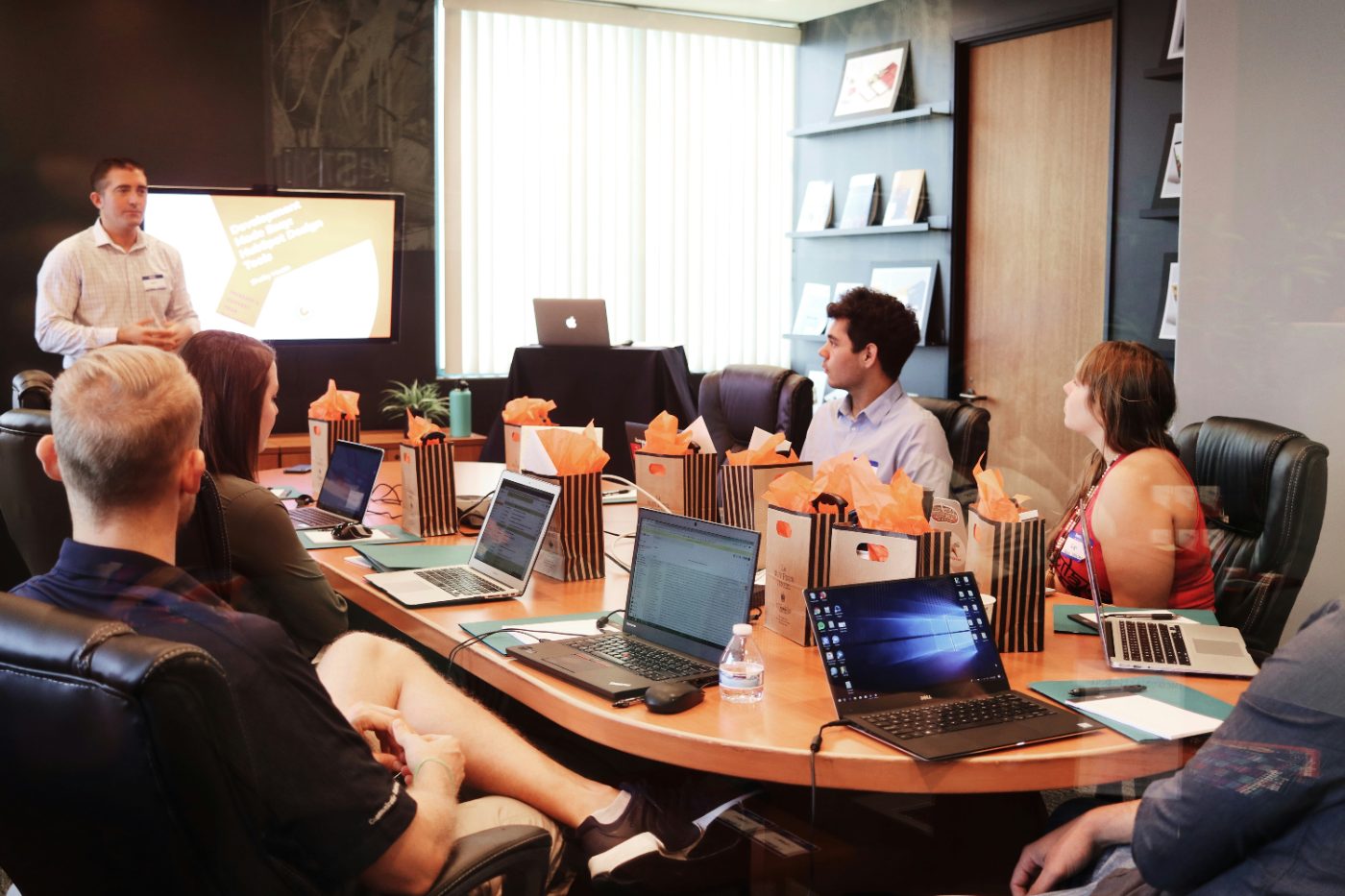 Consultant leading a hands-on workshop session around a conference table
