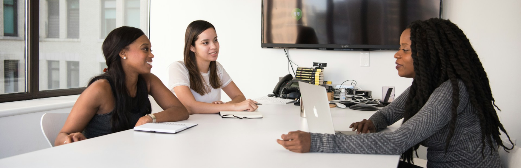 Recruiters and a candidate in an interview around a meeting table